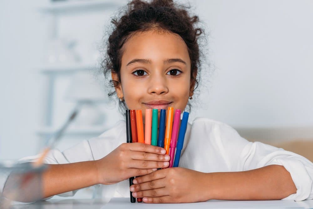 student with markers